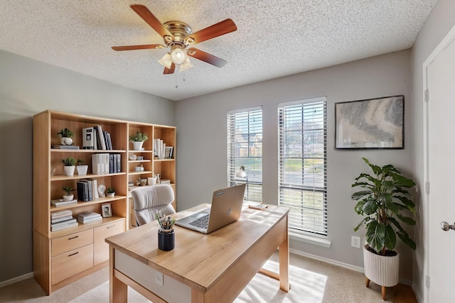 home office with ceiling fan, light carpet, and a textured ceiling