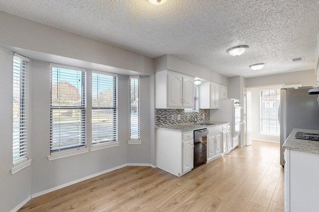 kitchen featuring sink, light hardwood / wood-style floors, decorative backsplash, white cabinets, and black appliances