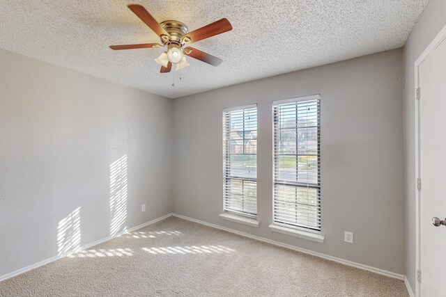 empty room with a textured ceiling, carpet floors, and ceiling fan