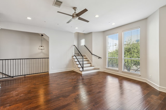 unfurnished living room with ceiling fan and dark wood-type flooring