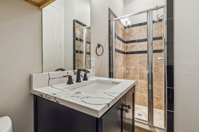 bathroom with vanity, toilet, and a shower with shower door