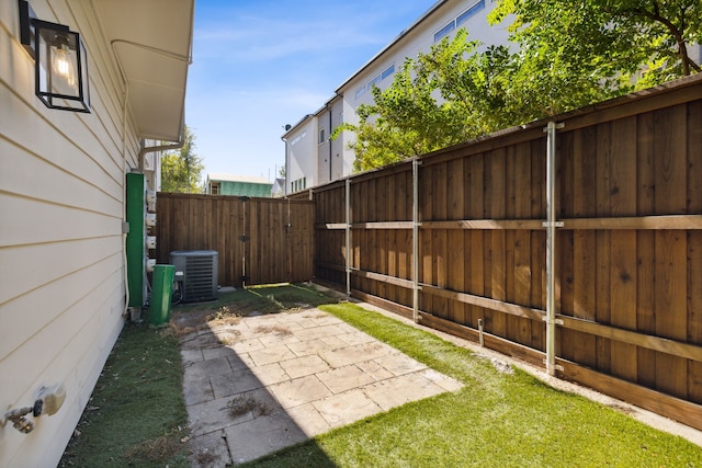 view of yard featuring central air condition unit and a patio area