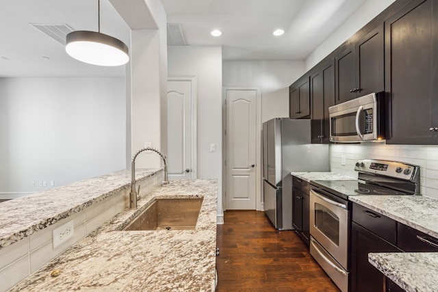 kitchen featuring light stone counters, sink, appliances with stainless steel finishes, and tasteful backsplash