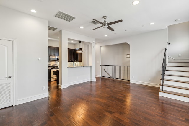 unfurnished living room with ceiling fan, sink, and dark wood-type flooring