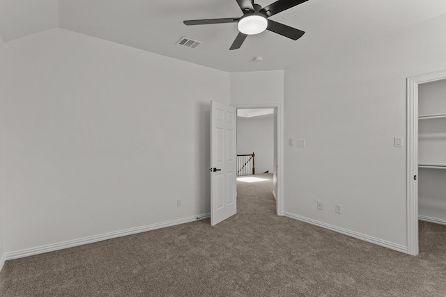 unfurnished bedroom with visible vents, a spacious closet, a ceiling fan, carpet flooring, and baseboards