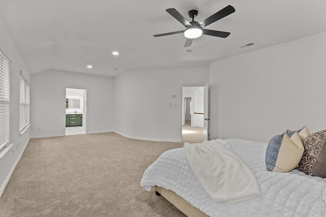 bedroom with vaulted ceiling, baseboards, visible vents, and light colored carpet