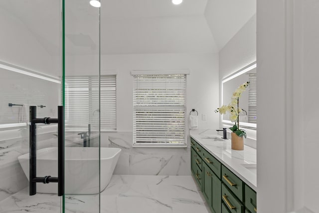 full bathroom featuring marble finish floor, double vanity, lofted ceiling, a soaking tub, and a sink