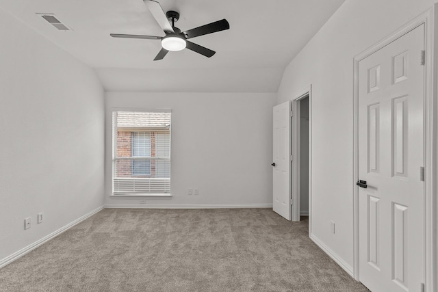 unfurnished bedroom with lofted ceiling, baseboards, visible vents, and light colored carpet