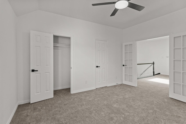 unfurnished bedroom with ceiling fan, lofted ceiling, light carpet, baseboards, and french doors