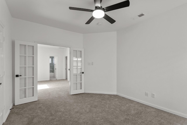 spare room featuring baseboards, visible vents, light colored carpet, ceiling fan, and french doors