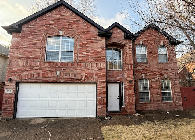 view of front of home featuring brick siding, driveway, and an attached garage