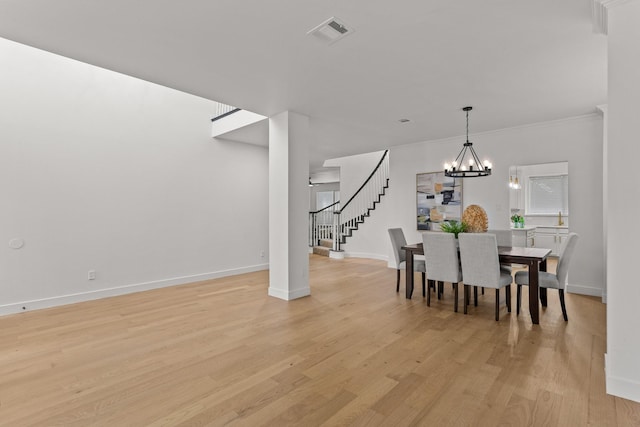 dining area with baseboards, visible vents, stairs, light wood-type flooring, and a chandelier