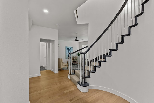 stairs with ceiling fan, recessed lighting, wood finished floors, and baseboards