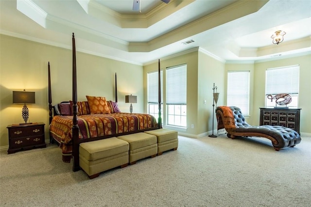 carpeted bedroom with ornamental molding and a raised ceiling