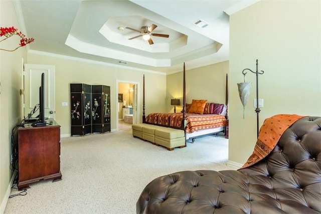 bedroom featuring crown molding, carpet floors, ensuite bathroom, and a tray ceiling