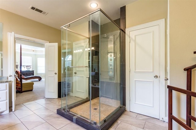 bathroom with a shower with shower door and tile patterned flooring