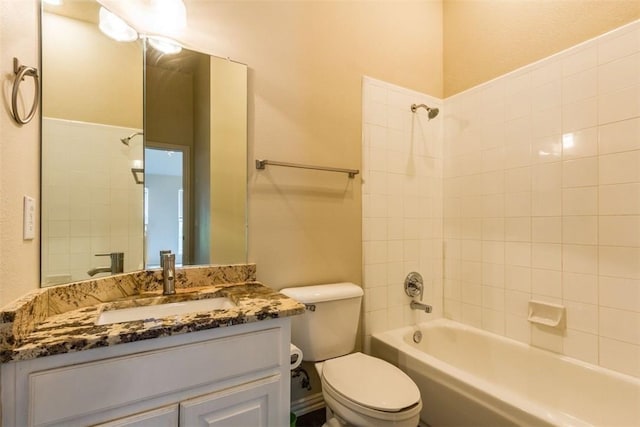 full bathroom featuring vanity, tiled shower / bath combo, and toilet