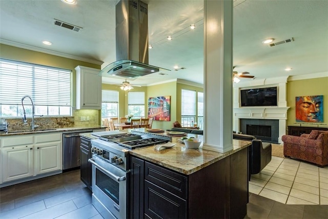 kitchen with sink, white cabinetry, a center island, island exhaust hood, and stainless steel appliances