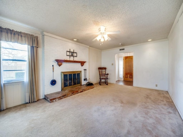 unfurnished living room with carpet floors, a fireplace, ornamental molding, and a textured ceiling