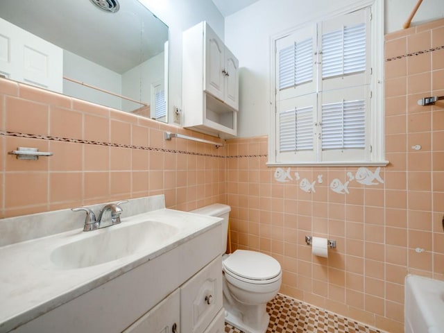 full bathroom featuring toilet, a bathtub, vanity, and tile walls