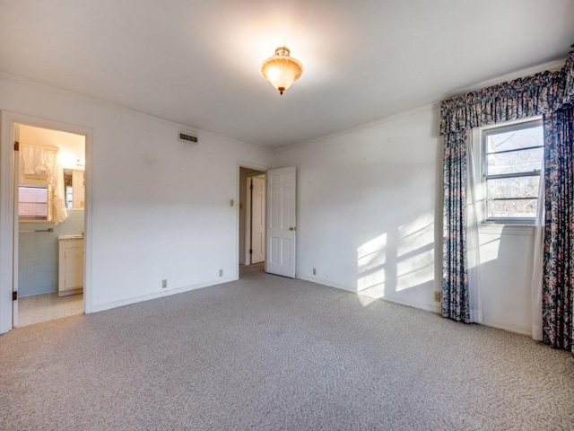 unfurnished room with light carpet, baseboards, visible vents, and crown molding