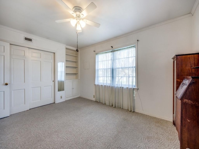 unfurnished bedroom with light carpet, a closet, visible vents, and crown molding