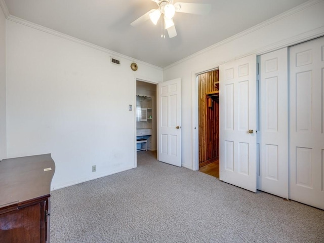 unfurnished bedroom featuring ceiling fan, light carpet, visible vents, baseboards, and crown molding