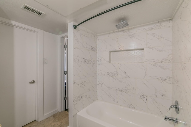 bathroom featuring tile patterned floors and tiled shower / bath combo