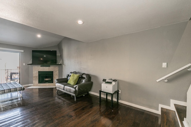 living room featuring a tiled fireplace and hardwood / wood-style floors