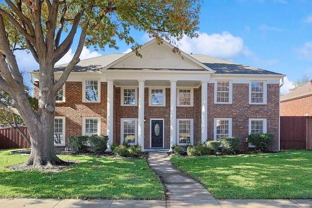 neoclassical home featuring a front lawn