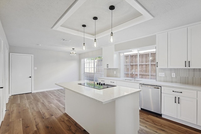 kitchen with stainless steel dishwasher, a raised ceiling, sink, a center island, and white cabinetry