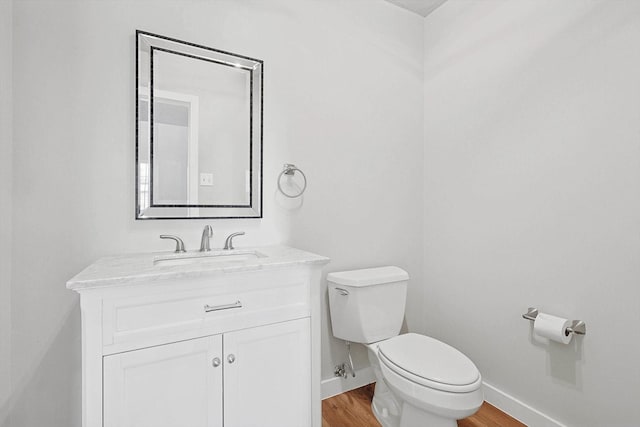 bathroom with vanity, wood-type flooring, and toilet