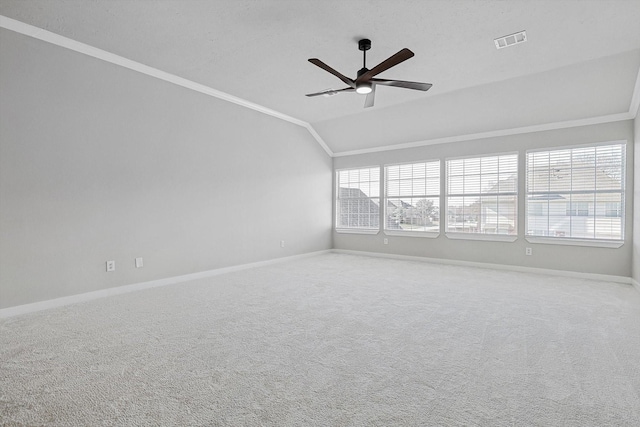 carpeted empty room featuring ceiling fan, plenty of natural light, lofted ceiling, and crown molding