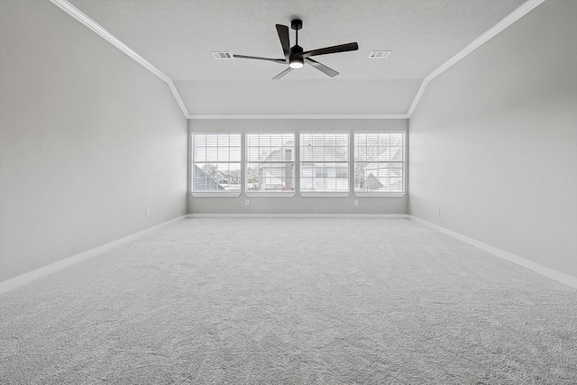 carpeted spare room featuring a wealth of natural light, vaulted ceiling, ceiling fan, and ornamental molding