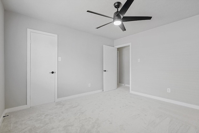 spare room featuring light carpet and ceiling fan