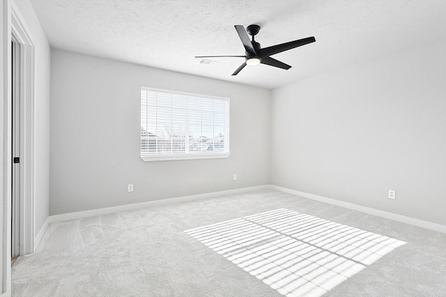 carpeted spare room featuring ceiling fan and a textured ceiling