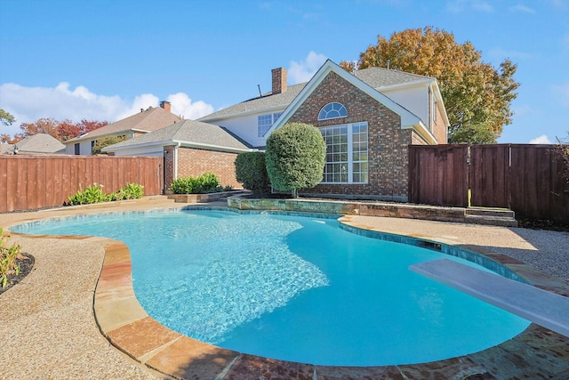 view of pool with a diving board