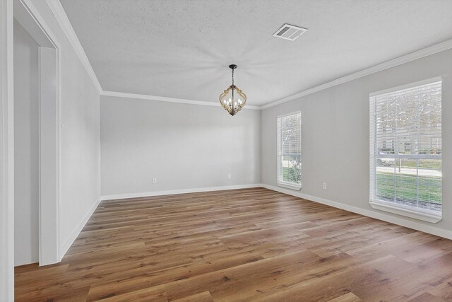 unfurnished room with a chandelier, hardwood / wood-style flooring, plenty of natural light, and crown molding