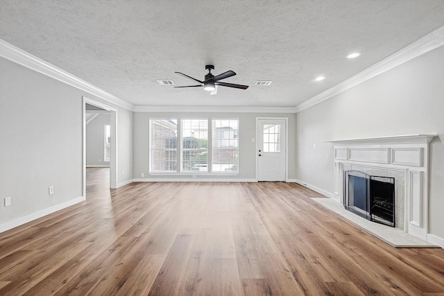 unfurnished living room featuring a textured ceiling, light wood-type flooring, ceiling fan, and ornamental molding