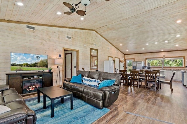 living room with ceiling fan, lofted ceiling, wooden walls, wood ceiling, and hardwood / wood-style flooring