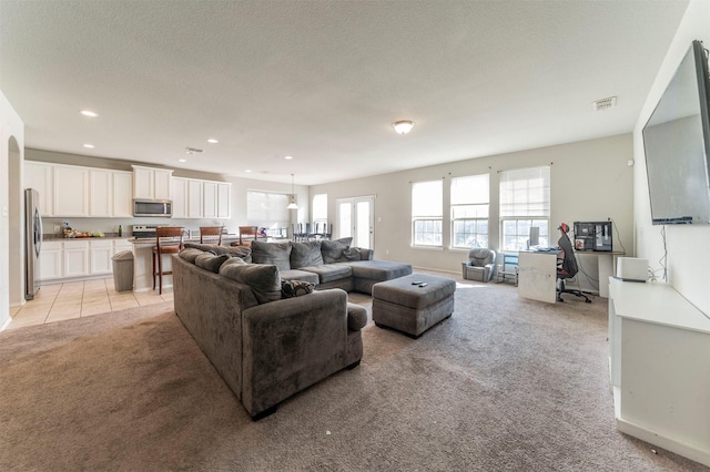 living room with a textured ceiling and light colored carpet