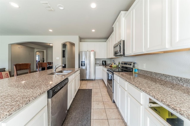 kitchen with white cabinetry, sink, light stone counters, light tile patterned flooring, and appliances with stainless steel finishes