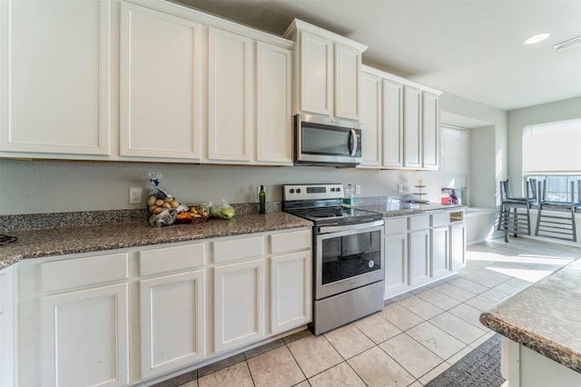 kitchen featuring light tile patterned flooring, white cabinetry, and appliances with stainless steel finishes