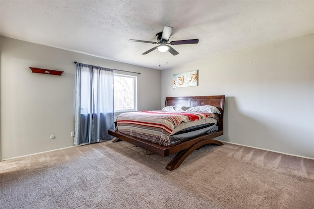 carpeted bedroom with ceiling fan and a textured ceiling