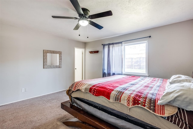 bedroom featuring carpet flooring, ceiling fan, and a textured ceiling