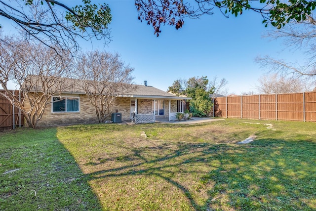 back of property featuring a lawn and central AC