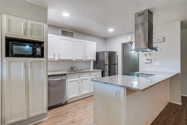 kitchen with black appliances, white cabinets, light stone countertops, light wood-type flooring, and island exhaust hood