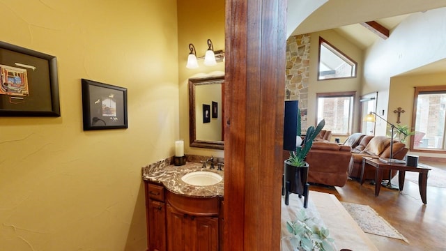 bathroom featuring vanity and high vaulted ceiling