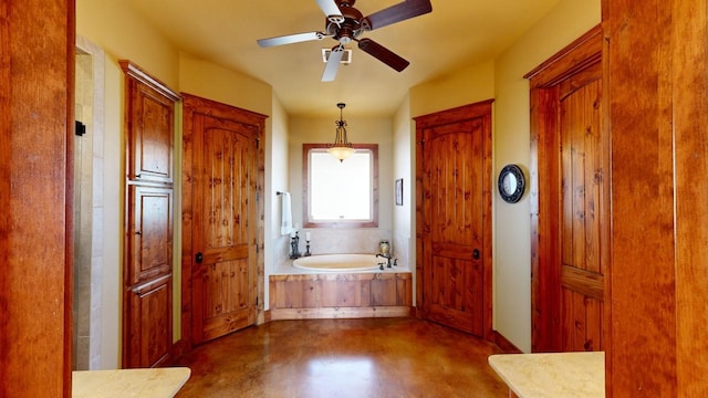 bathroom with ceiling fan, concrete flooring, and a bathtub