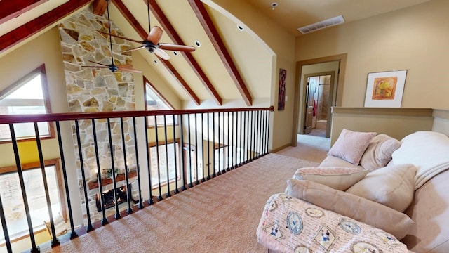 sitting room featuring beamed ceiling, plenty of natural light, and light carpet